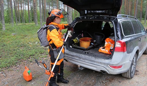 Sakari Mantila packar sina arbetsredskap i bilens baklucka vid skogsbilvägen.