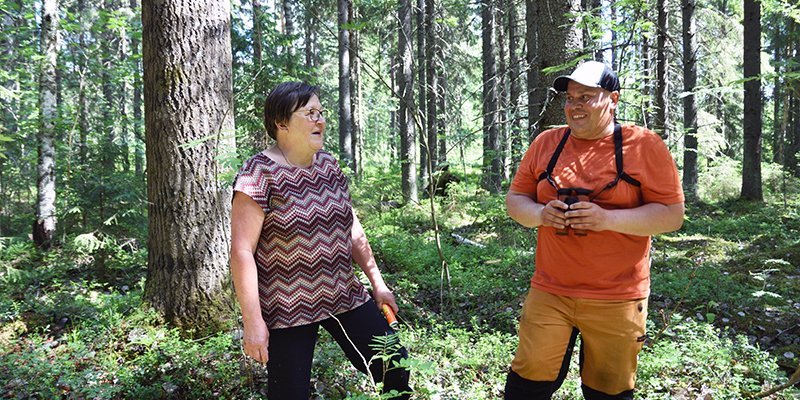 Raija Hämäläinen och Teemu Ukkonen diskuterar i skogen.