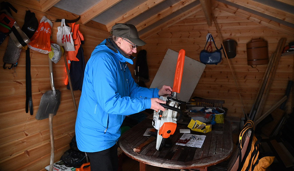 Viljami Kurth med motorsåg i lagerlokalen.